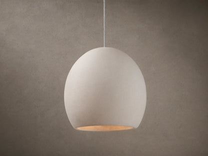 Arica Pendant with a spherical, light cream alabaster shade suspended from a thin cable, emitting a soft glow.