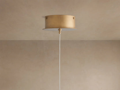 Close-up of the Arica Pendant's curved, textured natural alabaster shade with muted pink tones, glowing warmly from within.