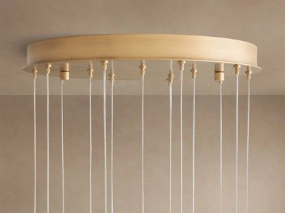 Arica Round Chandelier: Brass circular ceiling mount with numerous white suspension cables hanging vertically.
