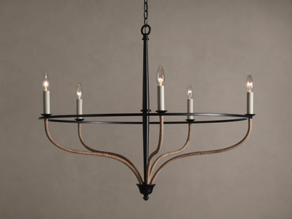 Black iron Rosalind chandelier with five illuminated candle-like bulbs. Curved arms are wrapped in natural rattan.