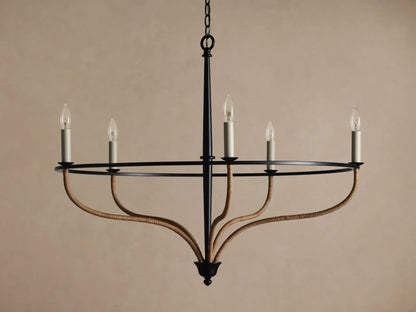 Black iron Rosalind chandelier with five illuminated candle-like bulbs. Curved arms are wrapped in natural rattan.