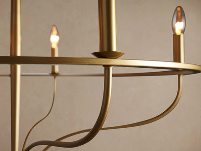 Rosalind Chandelier: Brass-finished iron, circular frame with 5 unlit candle-style bulbs, hanging against a plain wall.