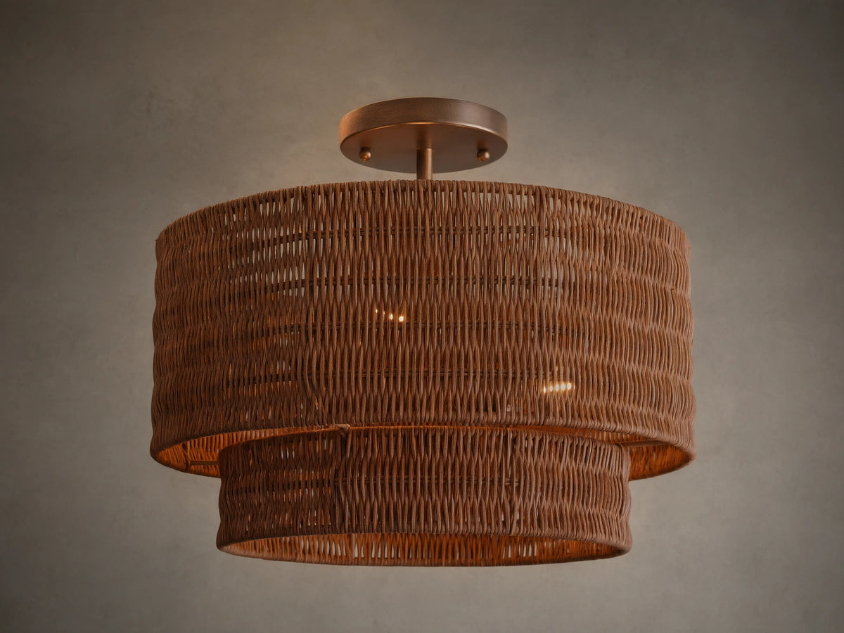 Paloma Flush Mount light with two-tiered handwoven brown rattan shade, metallic bronze canopy, illuminated against a light ceiling.