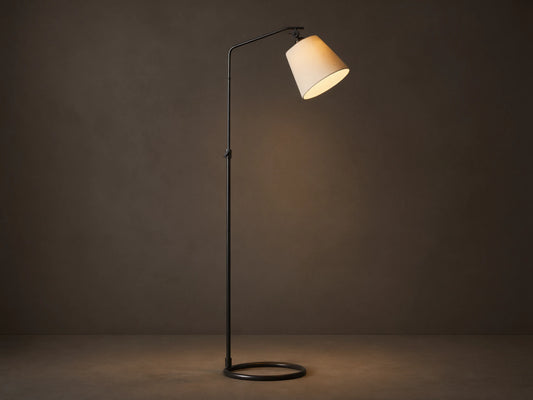 Kellen Floor Lamp: oil-rubbed bronze adjustable stand, angled beige linen shade, lit, on wood floor against plain wall.