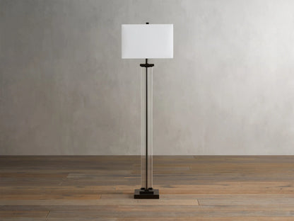 Base of the Dawson Floor Lamp featuring clear crystal columns and a metallic square base on a wooden floor with visible clear cord.