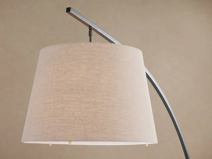 Tadeo Floor Lamp with an arched dark bronze arm, light linen shade, and rectangular espresso marble base, standing on a wood floor.