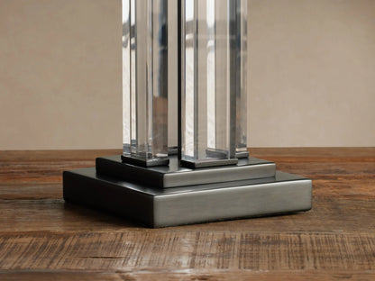 Dawson Table Lamp: rectangular cream shade, clear acrylic column stem with dark accents, resting on a rustic wood surface.