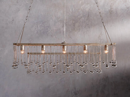 Aubrey Rectangular Chandelier with a silver handcrafted iron frame, hanging Italian glass crystals, and five glowing bulbs.