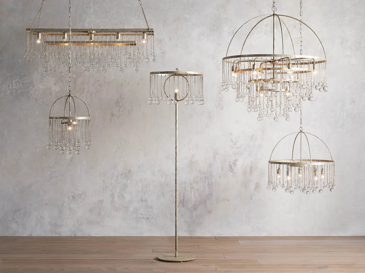 Aubrey Rectangular Chandelier with a silver handcrafted iron frame, hanging Italian glass crystals, and five glowing bulbs.