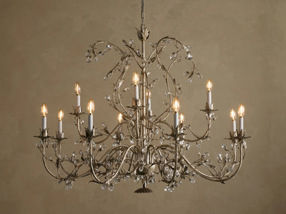 Claudette Chandelier: Ornate grey/silver-toned iron chandelier with 12 lit candle-style bulbs and numerous clear glass crystals.
