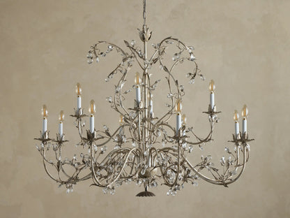 Claudette Chandelier: Ornate grey/silver-toned iron chandelier with 12 lit candle-style bulbs and numerous clear glass crystals.
