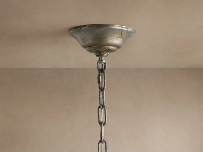 Close-up of Claudette Chandelier: golden-silver leaf frame, clear Italian glass crystals, and white candle-style light bulb.