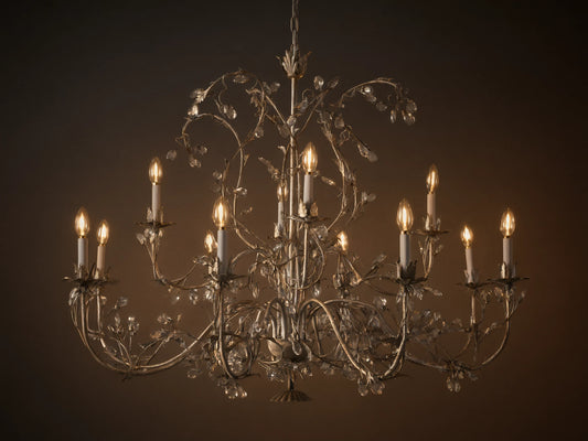 Claudette Chandelier: Ornate grey/silver-toned iron chandelier with 12 lit candle-style bulbs and numerous clear glass crystals.