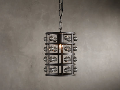 Iron cage pendant with antiqued metallic finish, adorned with Italian crystal spheres, hanging from a chain on a textured wall background.