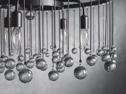 Aubrey Round Chandelier's ceiling mount with a dark brown iron finish, attached to a sturdy chain descending downwards.