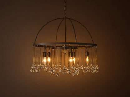 A round chandelier made of solid iron with five exposed bulbs and hanging glass accents, suspended by an iron chain.