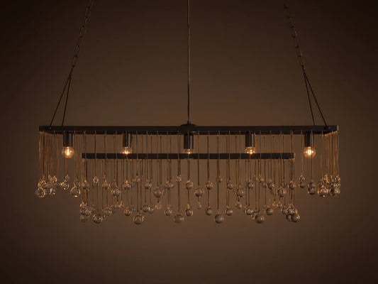 Aubrey Rectangular Chandelier with solid iron frame, hanging glass spheres, and five exposed bulbs, suspended by black iron chains.