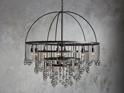 A round chandelier with a dark iron frame, featuring cascading glass orbs and five visible lit bulbs, hanging from a chain.