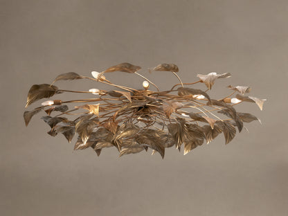 Ornate Ninfea Flush Mount with antiqued gold iron leaves and multiple illuminated candelabra bulbs on a neutral ceiling.