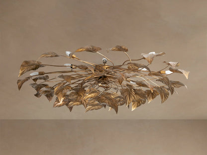 Ornate Ninfea Flush Mount with antiqued gold iron leaves and multiple illuminated candelabra bulbs on a neutral ceiling.