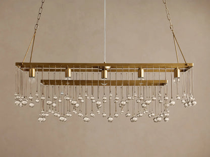 Aubrey Rectangular Chandelier: Gold iron frame, clear glass beads cascading, 4 exposed bulbs, hanging on chains.