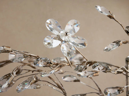 Detailed view of Fiore Crown Chandelier showing a clear faceted crystal flower & numerous crystal leaf accents on silver branches.