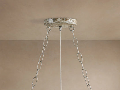 Close-up of Fiore Crown Chandelier's distressed silver/white ceiling mount with two hanging chains and a wire against a beige ceiling.