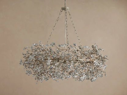 Fiore Crown Chandelier, oval silver-tone fixture adorned with many clear crystal leaves, suspended by metal chains.
