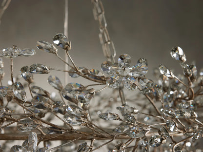 Close-up of the Fiore Crown Chandelier with antiqued silver/gold branches adorned with sparkling, faceted clear crystal flowers and leaves.