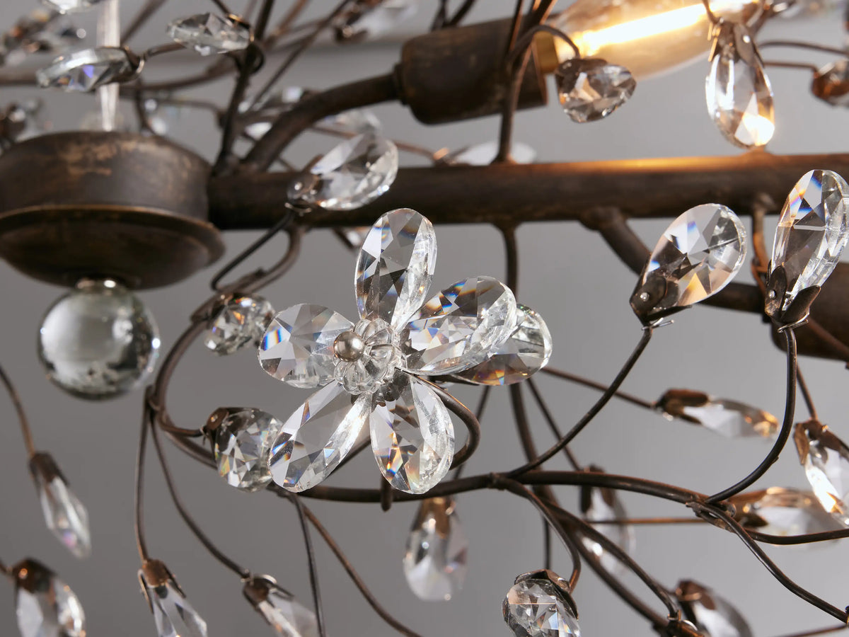 Fiore Linear Chandelier: horizontal, dark iron frame with delicate branches adorned with clear crystal flower accents, suspended by chains.