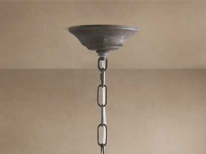 Detailed Fiore Linear Chandelier close-up: clear crystal flower & teardrop accents on dark antiqued bronze metal, warm bulb glow.