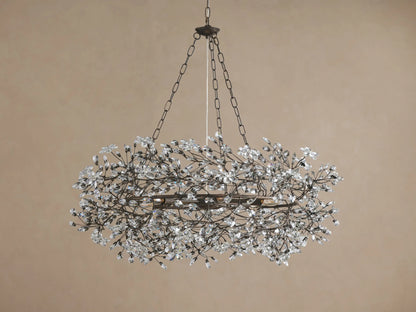 Antique bronze Fiore Crown Chandelier with a circular frame, covered in numerous clear crystal flower-like adornments, hanging.