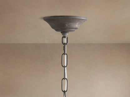 Fiore Crown Chandelier: Distressed bronze ceiling canopy and thick chain hanging from a light beige ceiling.