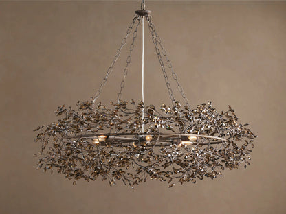 Fiore Crown Chandelier, an antique metal wreath-shaped fixture with many amber leaf-like crystals, hanging from chains.