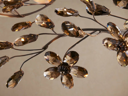 Close-up of Fiore Crown Chandelier showing dark metal branches with sparkling amber faceted crystal flowers and leaves.