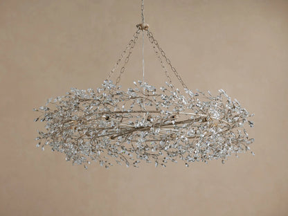 Fiore Crown Chandelier: Ornate oval chandelier in antiqued champagne, densely adorned with shimmering clear crystal leaf clusters.