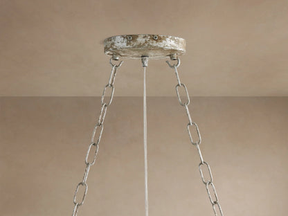 Fiore Crown Chandelier's distressed silver ceiling canopy & three chains hang from a light beige ceiling.