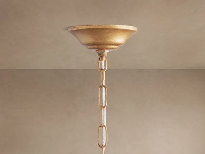 Fiore Crown Chandelier's gold ceiling canopy and chain with clear accents, hanging from a neutral-colored ceiling.