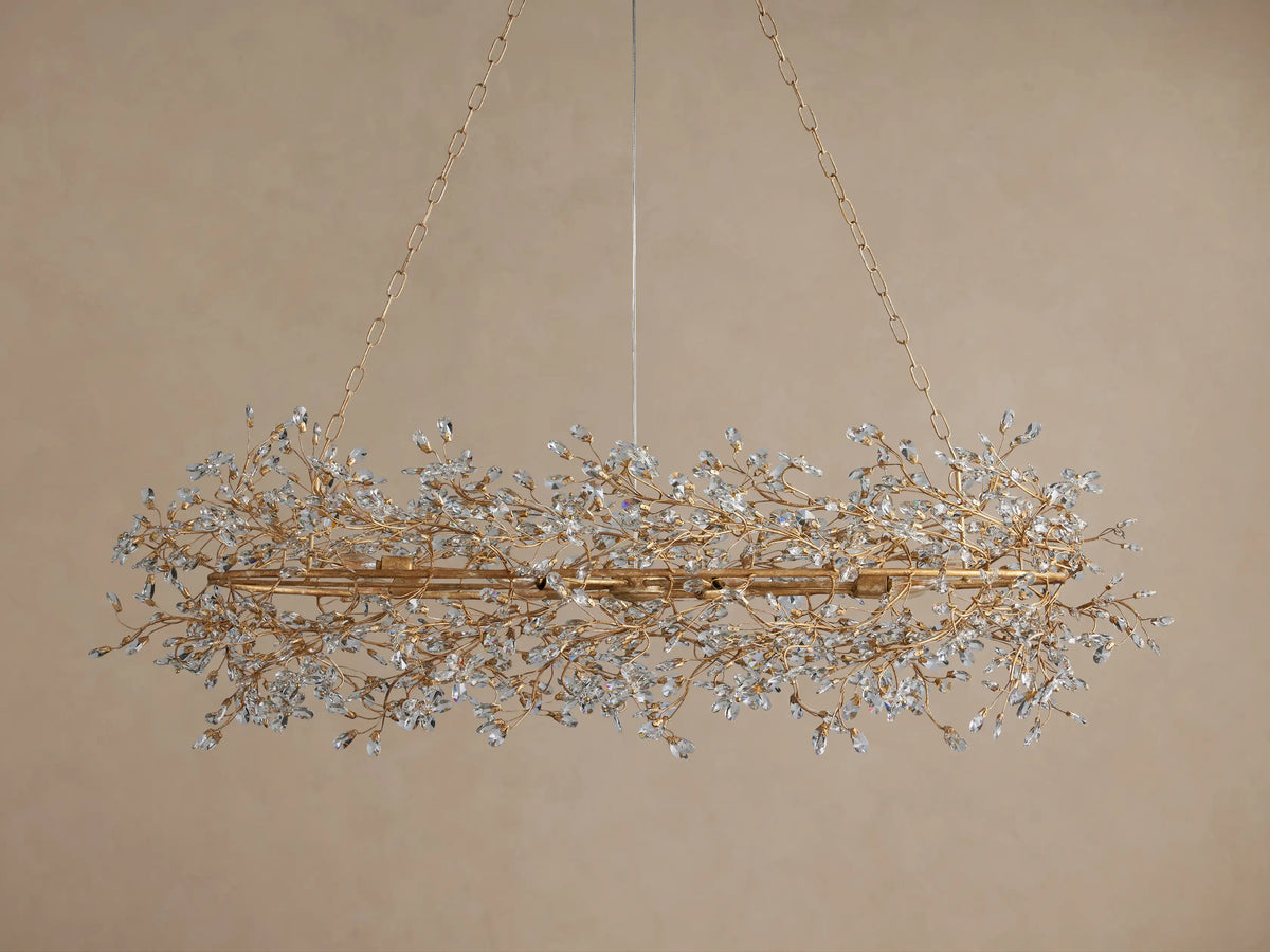 Fiore Oval Chandelier with an antiqued gold frame, featuring numerous sparkling clear crystal leaves, suspended by gold chains.