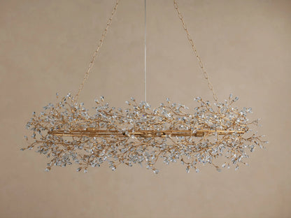 Fiore Oval Chandelier with an antiqued gold frame, featuring numerous sparkling clear crystal leaves, suspended by gold chains.