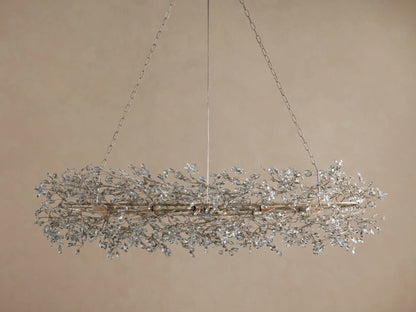 Fiore Oval Chandelier, antiqued silver iron with sparkling clear crystal leaves, hanging from chains against a neutral wall.
