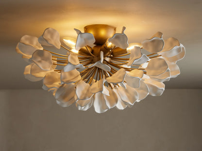 Lunaria Flush Mount with cascading white ceramic leaves and a brass base, lit softly from above, mounted on a ceiling.
