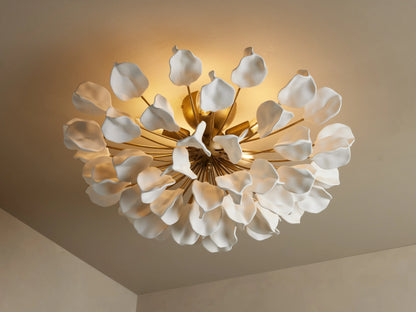 Lunaria Flush Mount with ceramic leaves resembling petals, arranged around golden iron stems, emitting warm light.