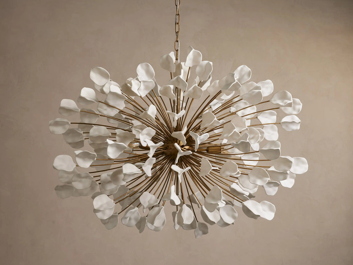 Lunaria Chandelier featuring a burst of 160 ceramic leaves in white and gold tones; warm light emitted from center bulbs.