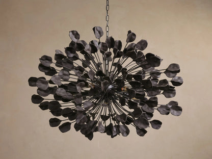 Lunaria Chandelier with spherical design, iron structure, and 160 ceramic leaves. Warm light emanates, casting intricate shadows.
