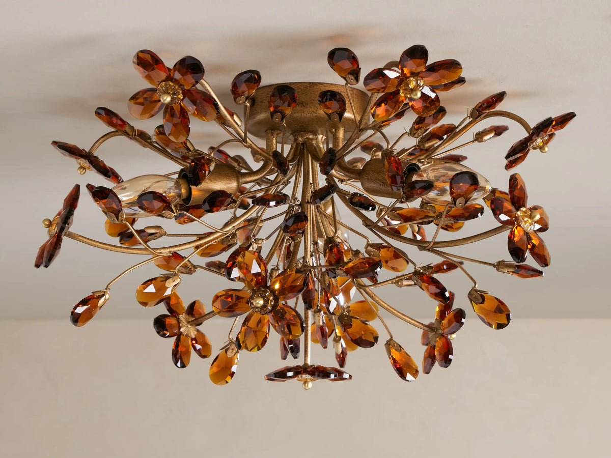 Ornate gold Fiore Flush Mount with amber crystal flowers & leaves, lit against a ceiling, from below.