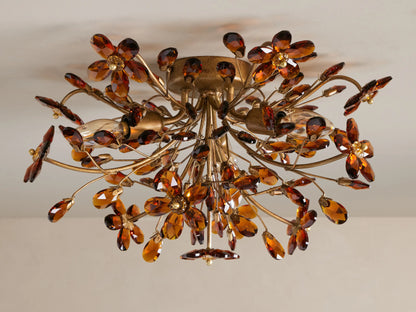 Ornate gold Fiore Flush Mount with amber crystal flowers & leaves, lit against a ceiling, from below.