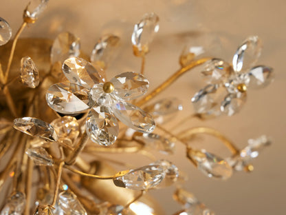Fiore Flush Mount: Gold-toned flush mount light with numerous clear crystal flowers and teardrop shapes, mounted on a ceiling.
