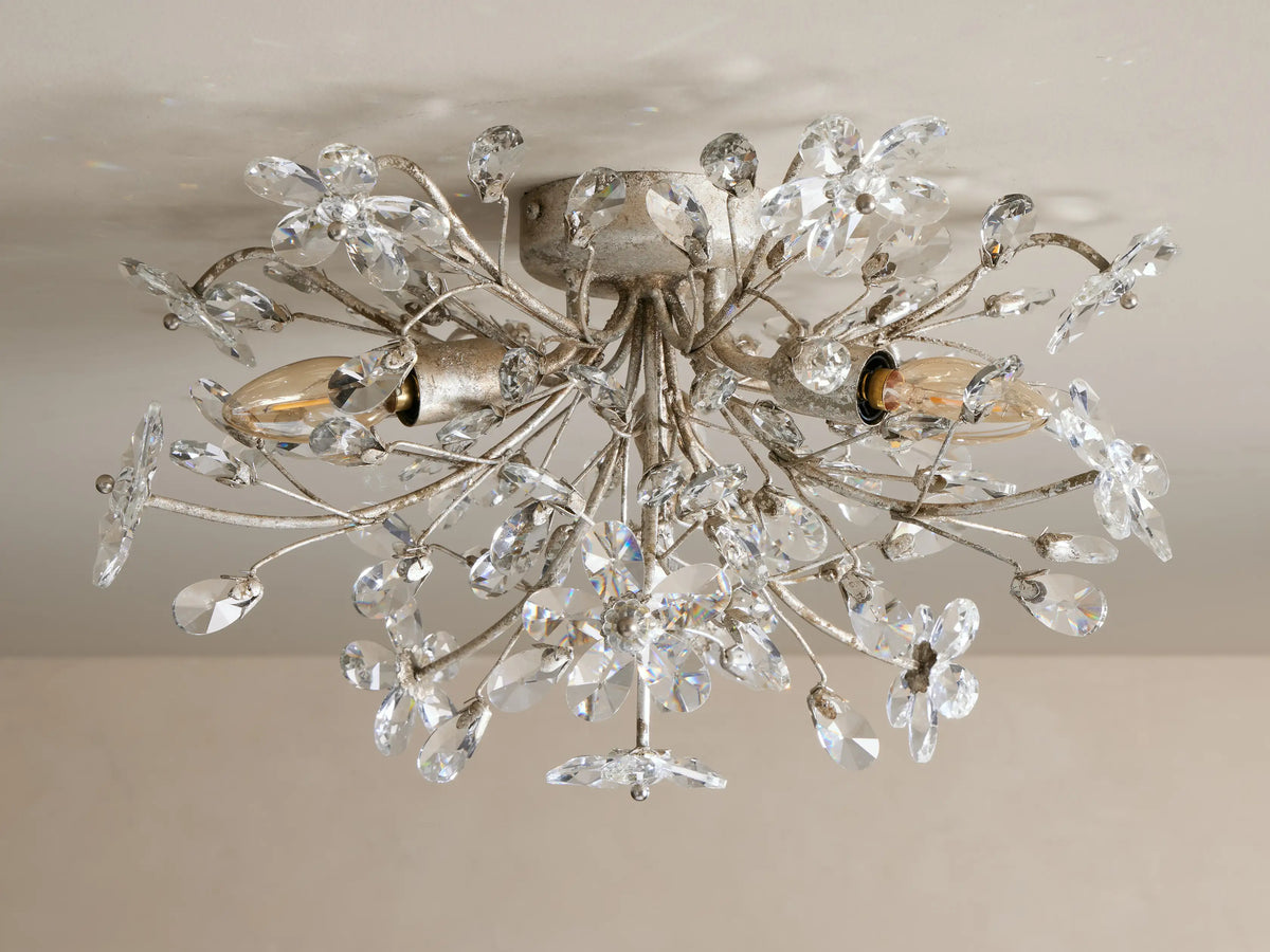 Fiore Flush Mount light fixture with intricate antique silver floral branches adorned with clear crystal flowers and leaves, illuminated.