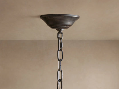 Close-up of Nicoletta Round Chandelier, showing distressed bronze leaves, smoke-colored crystals, and warm glowing bulbs.